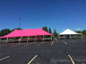 pole tent with custom red tent top set up in parking lot